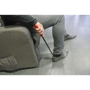 senior enfilant une chaussure debout avec un chausse-pied long