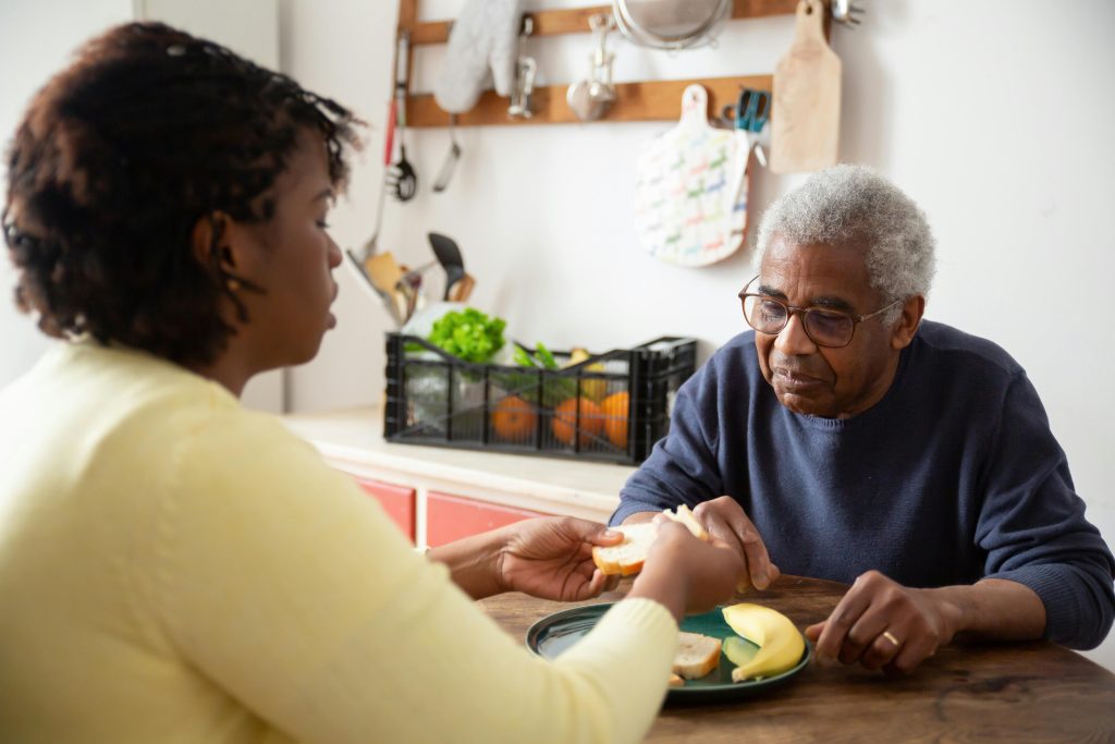 Aidant en conversation calme avec son parent âgé au sujet de l'aide à domicile